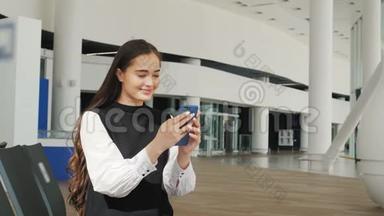 戴着笔记本电脑、手机和行李坐在机场微笑的亚洲女商人的侧面肖像。 <strong>终点</strong>站铁路